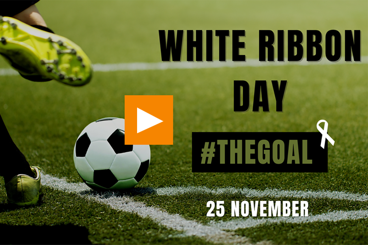 White Ribbon Day #TheGoal 25 November 2022 football on pitch with a footballer leg with boot coming into shot to kick football